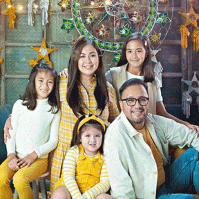 a family posing for a picture in front of a christmas wreath