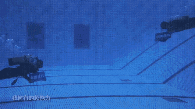two scuba divers are swimming in a pool with chinese writing on it