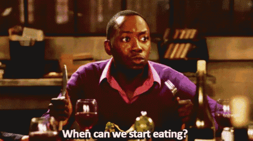 a man is sitting at a table holding a knife and fork and asking when can we start eating .