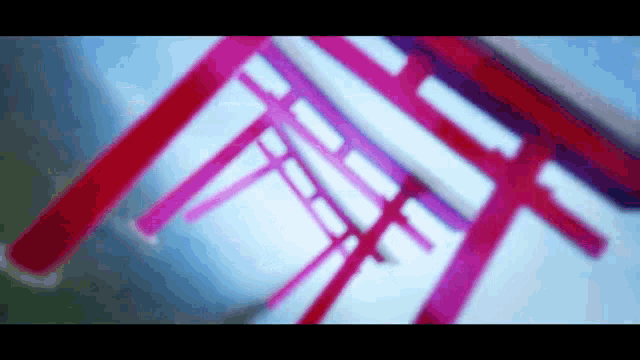 a red and pink torii gate is against a blue sky .