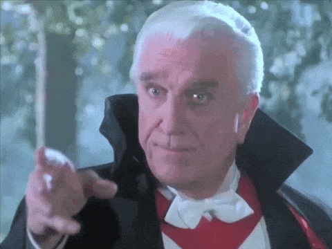 an older man in a tuxedo and bow tie is pointing at the camera