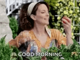 a woman is eating an apple in a garden with the words good morning below her