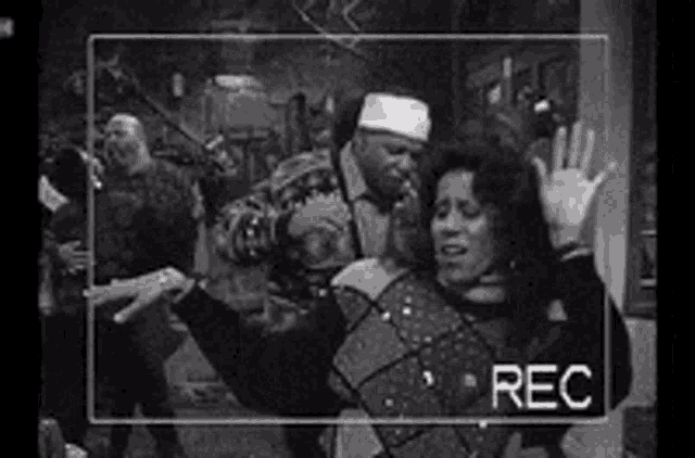 a black and white photo of a group of people dancing with the word rec on the bottom right .