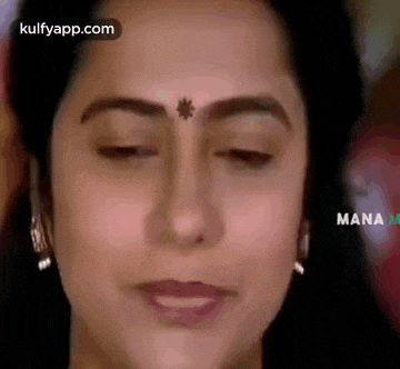 a close up of a woman 's face with a bindi on her forehead