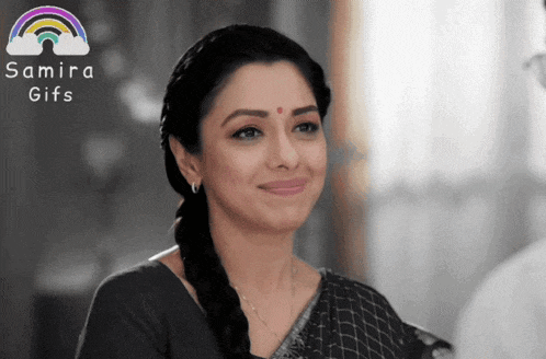 a woman is smiling in front of a sign that says samira gifs on it