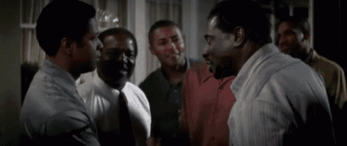 a group of men are talking to each other in a room