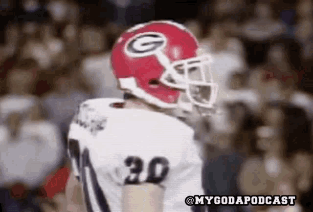 a football player wearing a red helmet with a g on it .