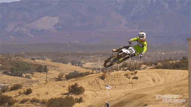 a dirt rider is doing a trick on a dirt road