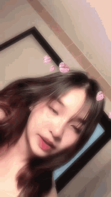 a girl taking a picture of herself with hearts on her hair