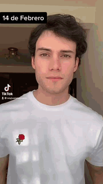 a man is wearing a white t-shirt with a rose on it and the date 14 de febrero on the bottom
