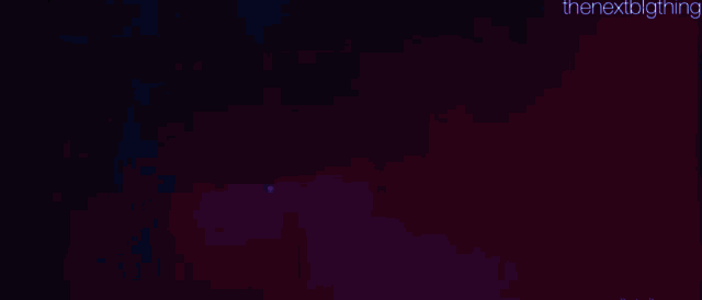 a person is standing in a dark room with blue smoke coming out of their mouth .