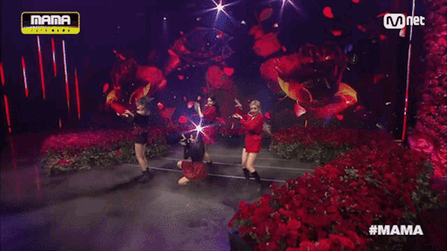 a group of women are performing on a stage with roses in the background and the words mama on the top
