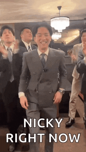 a man in a suit and tie is dancing with a group of men .