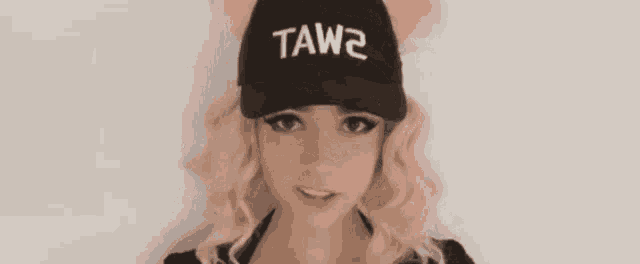 a woman wearing a black hat that says tawa on it