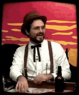 a man in a hat and suspenders is sitting at a table with a bottle of beer in front of him
