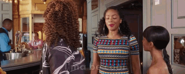 three women are standing next to each other in a room with the word ima on the bottom right corner