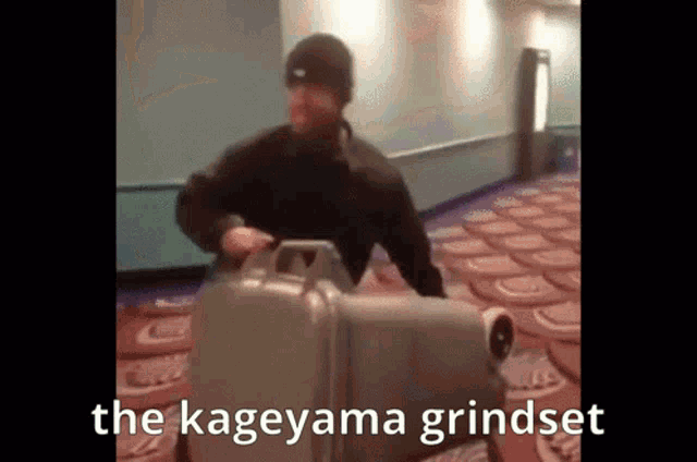 a man is pushing a suitcase with the words the kageyama grindset on the bottom