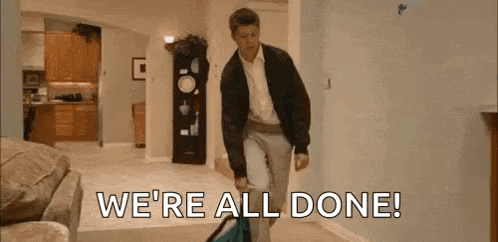 a man is walking through a living room carrying a bag and saying `` we 're all done '' .