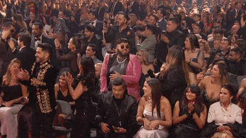 a man in a pink jacket is surrounded by a crowd