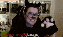 a woman wearing cat ears and glasses is smiling in front of a sign that says pandora_dark