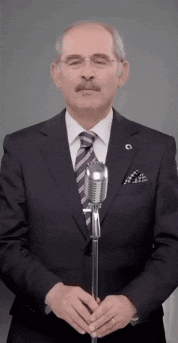 a man in a suit and tie is holding a microphone