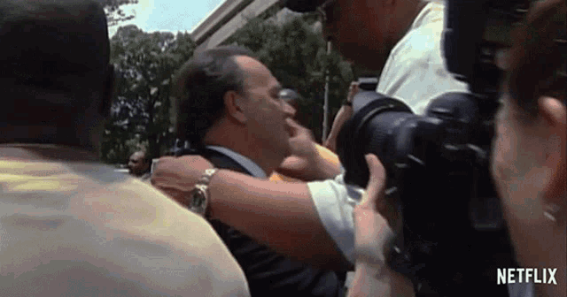 a man in a suit is being photographed by a netflix camera .