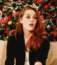 a woman sitting on a couch with a christmas tree in the background