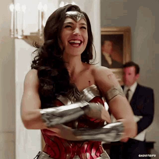 a woman in a wonder woman costume is laughing and holding a sword .