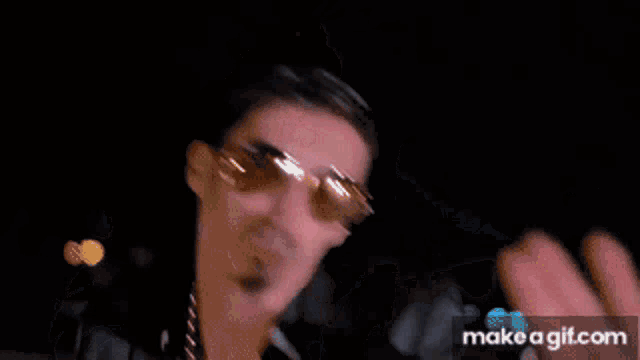 a man with sunglasses and a chain around his neck