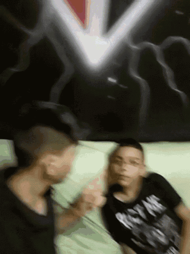 a blurry picture of two boys with one wearing a shirt that says ' nike ' on it
