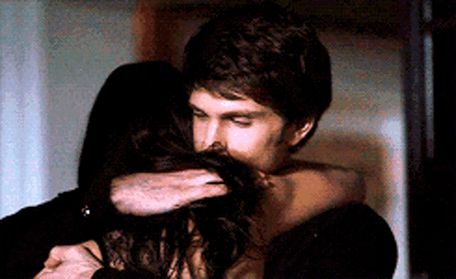 a man and a woman are hugging each other