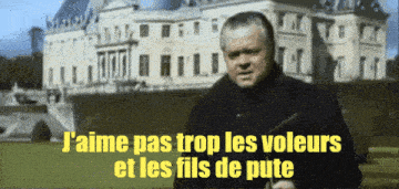 a man stands in front of a castle with the words j'aime pas trop les voleurs et les fils de pute