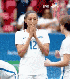 a female soccer player wearing a white jersey with the number 12 on it