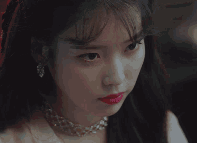 a close up of a woman 's face with red lipstick and earrings