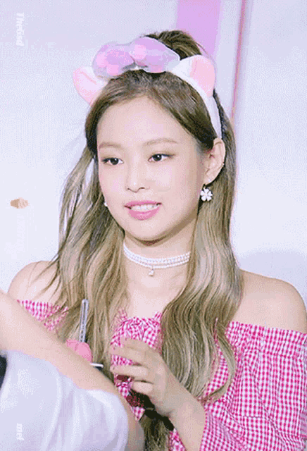 a woman wearing a headband with cat ears and a choker