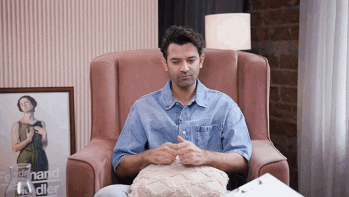 a man is sitting in a chair with a picture of a woman on the wall behind him that says " edward hadler "