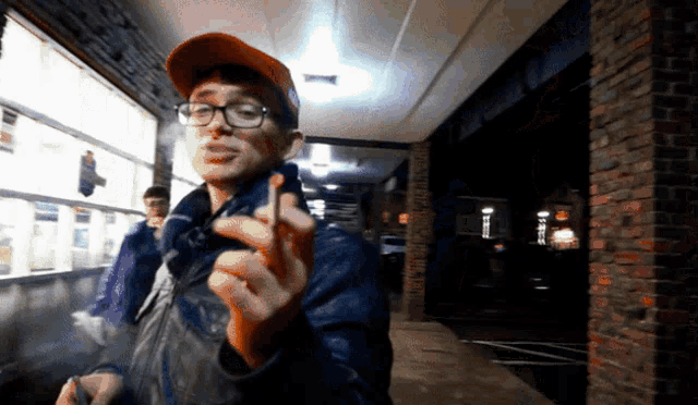 a man wearing glasses and a red hat is smoking