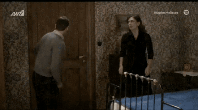 a man and a woman are standing in a room with a tv screen behind them that says #agnesmalisses