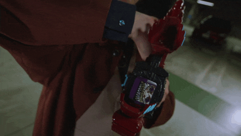 a person is holding a red object with a purple sticker on it that says ' samurai ' on it