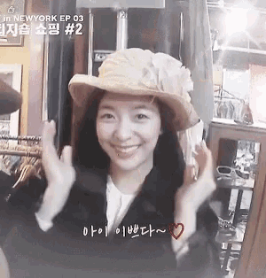 a woman wearing a hat with a flower on it is smiling for the camera