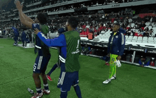 a soccer player with the number 5 on his jersey is hugging another player