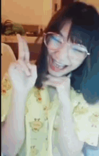 a woman wearing glasses and a yellow shirt is smiling