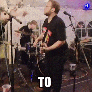 a man playing a guitar in front of a microphone with the word to in white letters