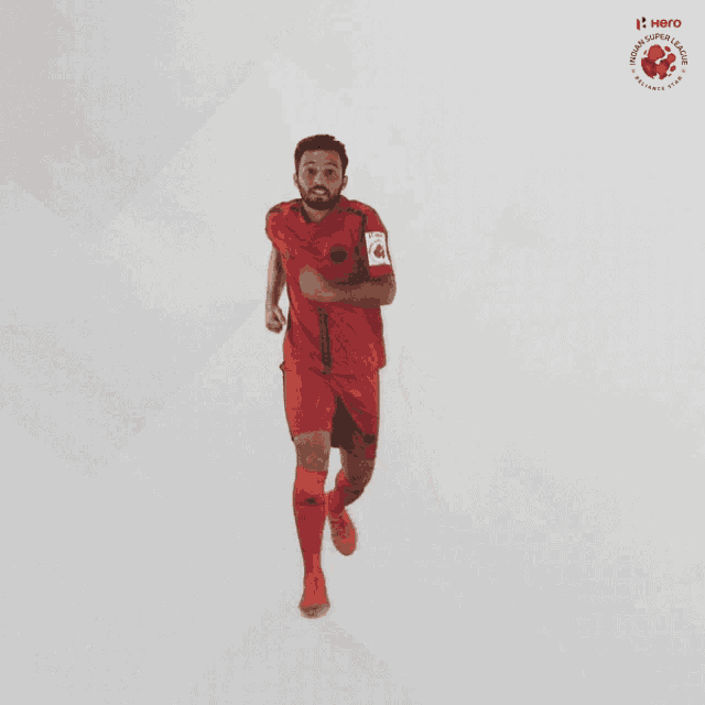 a man in a red shirt and shorts is standing in front of a hero logo