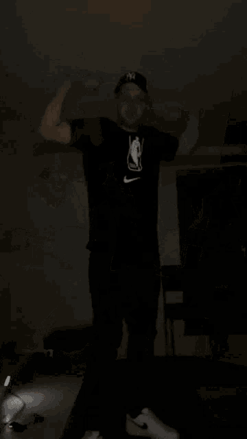 a man wearing a hat and a t-shirt with the nba logo on it .