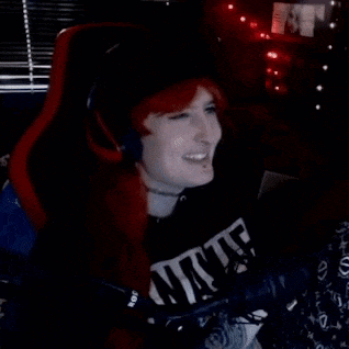 a woman with red hair is sitting in a chair with headphones on and a microphone .