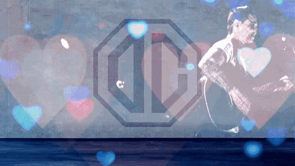 a man playing a guitar in front of a md logo with hearts in the background
