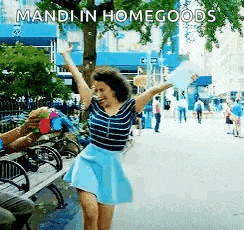 a woman in a blue skirt is dancing in a park with the words mandi in home goods written on the bottom