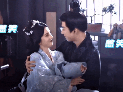 a man is holding a woman in his arms in front of a sign that says ' chinese ' on it