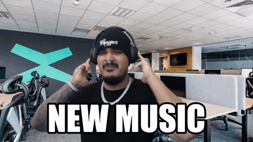 a man wearing headphones says " new music " on the screen